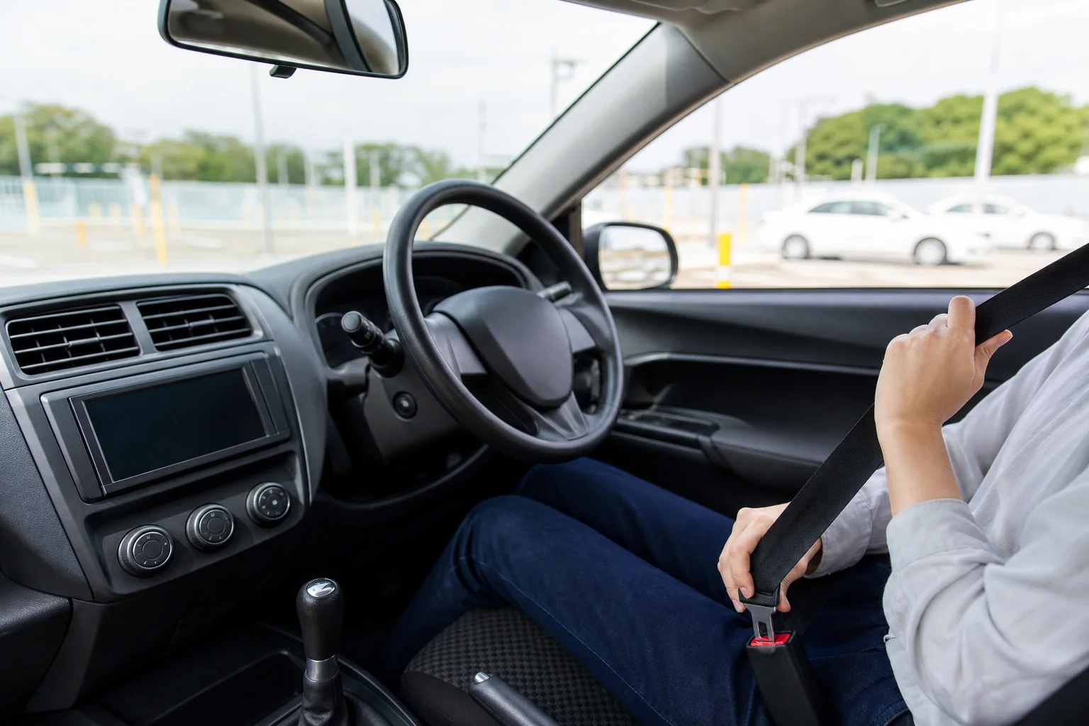 運転席に座ってから、シートベルトやミラーを整えている手元のイメージ写真